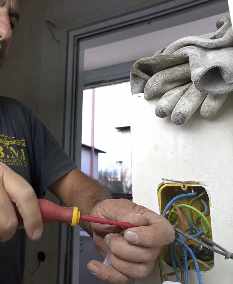 Mani al lavoro su una scatola di derivazione elettrica